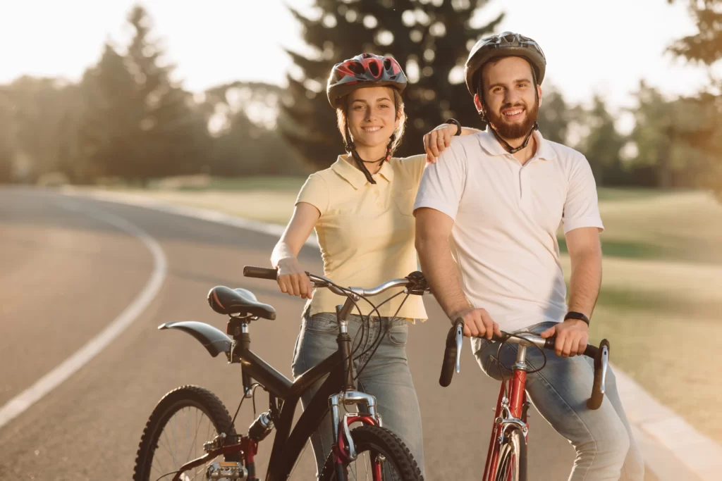 smiling couple enjoying a bike ride on paved trail utc